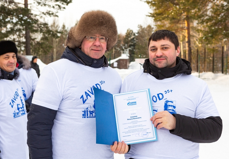 Валерий Кузьменок, заместитель директора завода награждает Михаила Атрошонка, электромонтера по ремонту и обслуживанию электрооборудования